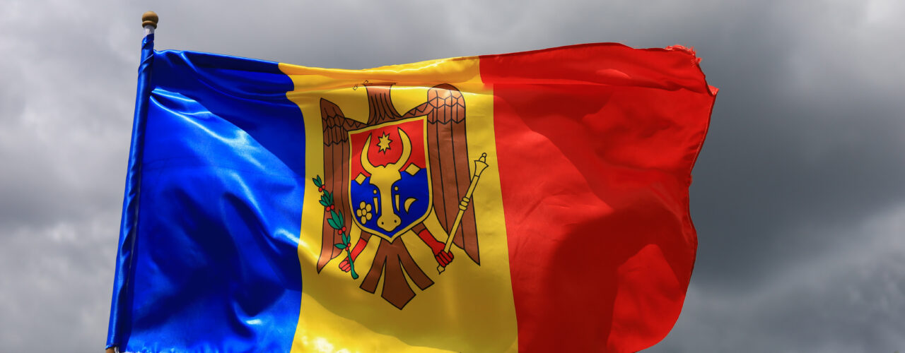 The official flag of the state of the Republic of Moldova against the sky.