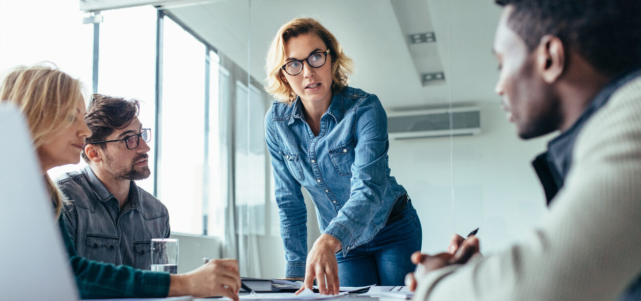 Businesswoman standing and leading business presentation. Female executive putting her ideas during presentation in conference room.