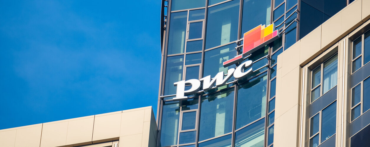 PwC logo on glass facade, high-rise glass office building against blue sky, finance and consulting, global economy, professional financial services in Germany, Frankfurt - February 9, 2025
