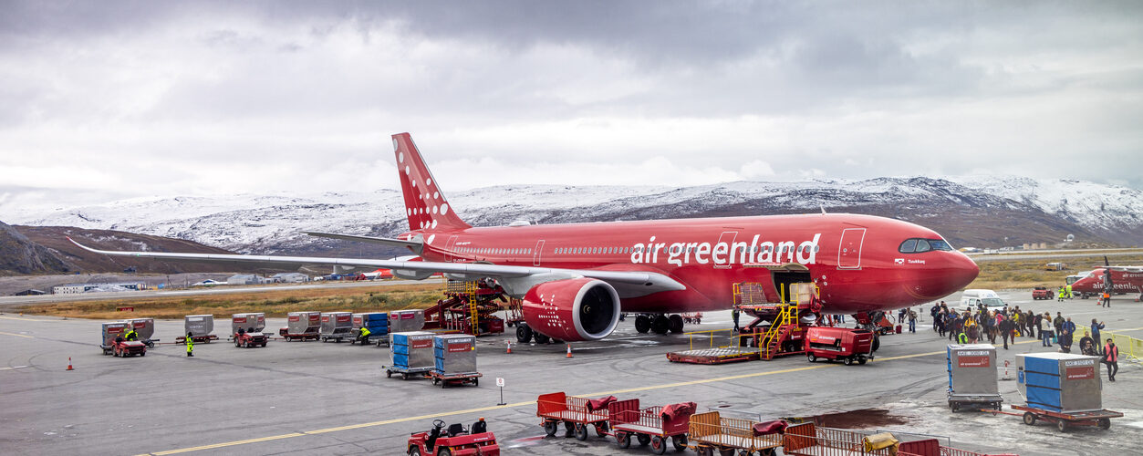 Kangerlussuaq, Søndre Strømfjord, Greenland, Denmark - September 1st 2024: Passengers walking from an Airbus A330-841 from Air Greenland parked on the tarmac surrounded by luggage carts in the airport which where build as an air base for the US Air Force during 2. world war - and today it is an important hub for traffic to overseas destinations