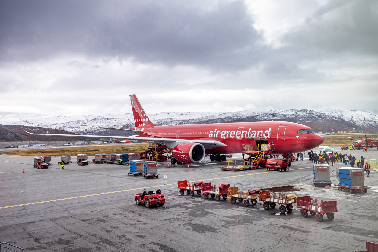 Kangerlussuaq, Søndre Strømfjord, Greenland, Denmark - September 1st 2024: Passengers walking from an Airbus A330-841 from Air Greenland parked on the tarmac surrounded by luggage carts in the airport which where build as an air base for the US Air Force during 2. world war - and today it is an important hub for traffic to overseas destinations