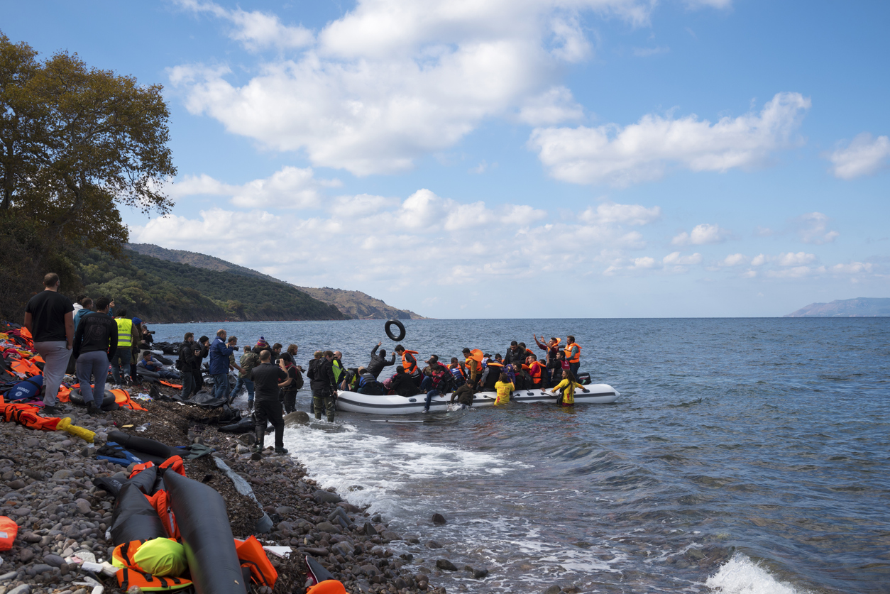 Skala Sikamineas, Lesbos, Greece - October 25, 2015: An inflatable boat filled with refugees and other migrants arrives on the north coast of the Greek island of Lesbos, where it is met by volunteers and photographers. More than 500,000 migrants have crossed from Turkey to the Greek islands so far in 2015.