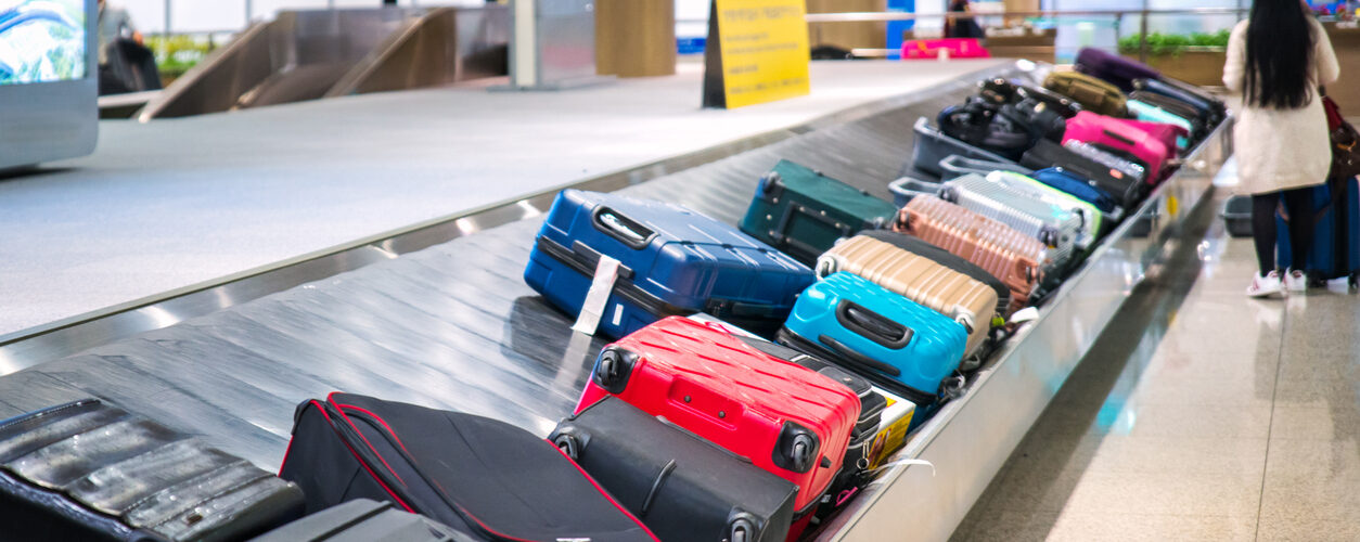 Traveler waiting for a travel bag on the belt in airport after arrival to airport destination flight