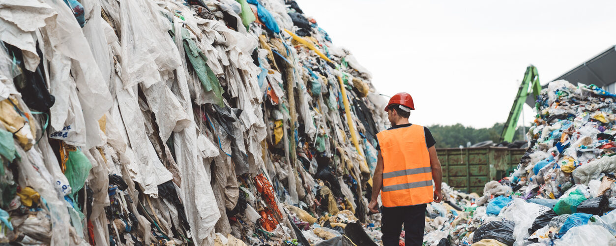 A worker walking between the heaps of garbage