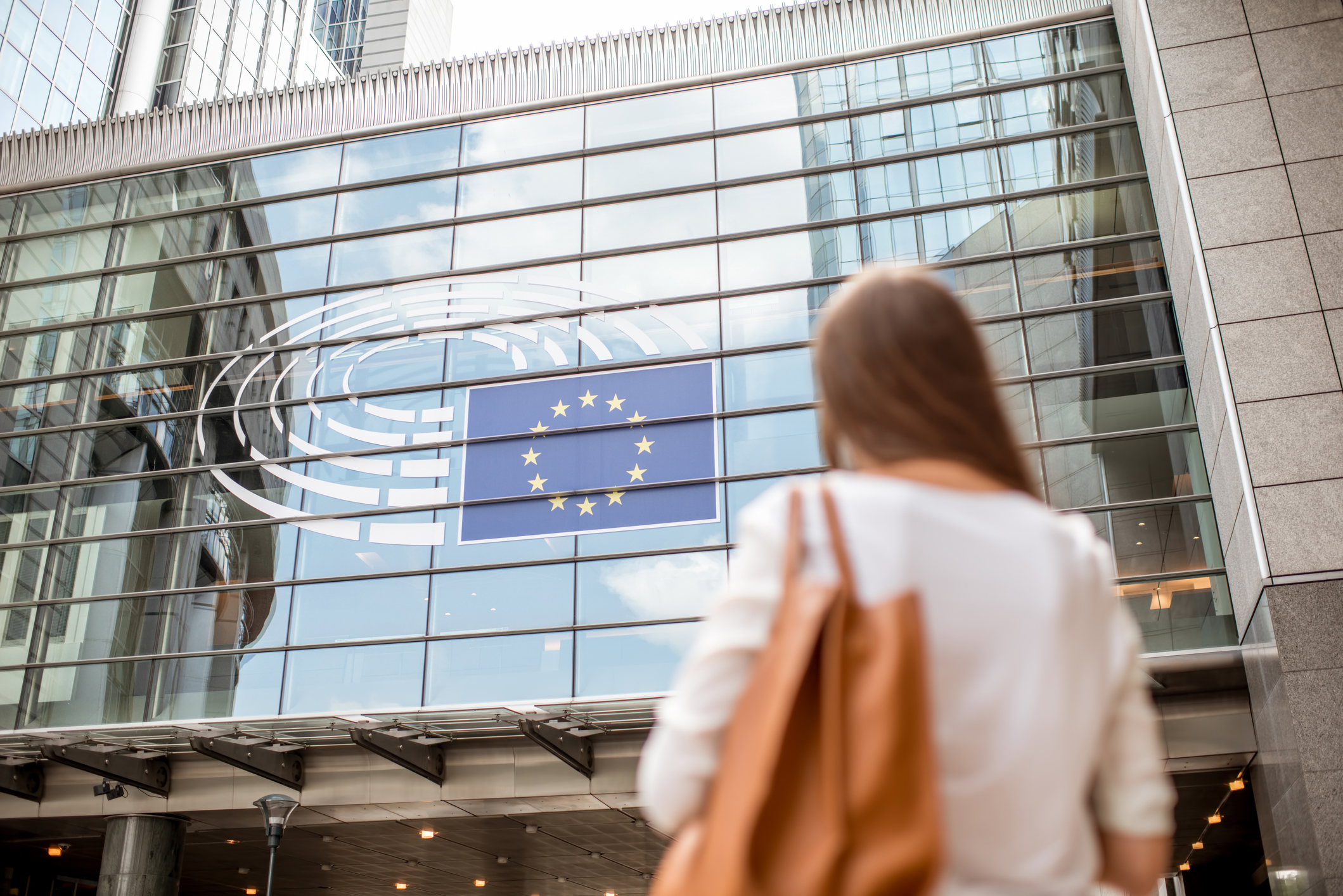 Young businesswoman standing back near the Parliament building of European Union in Brussel city