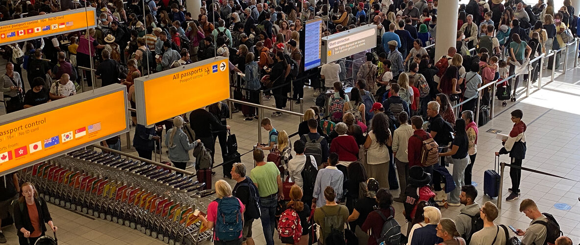 Passagiers wachten op vertraging en compensatie op Schiphol.