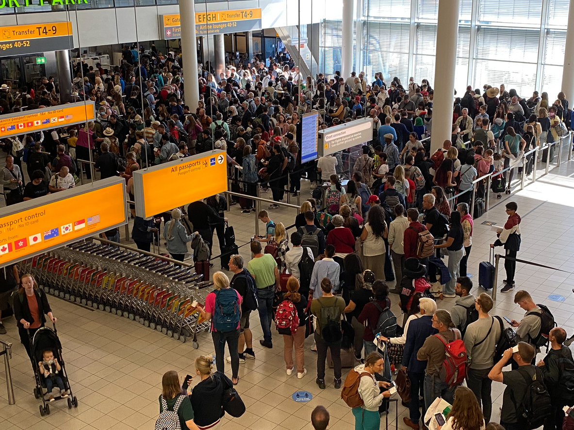 Passagiers wachten op vertraging en compensatie op Schiphol.