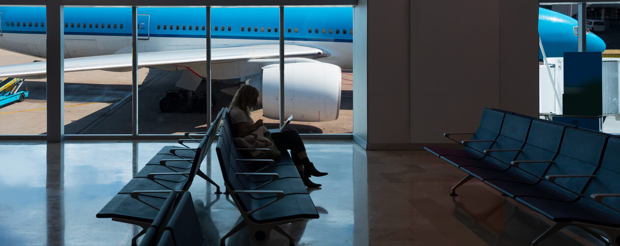 Passagier wacht op vertraagde vlucht op Schiphol.