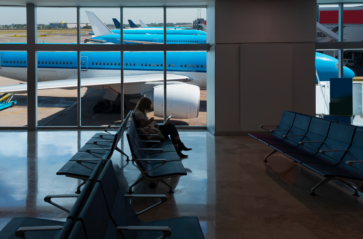 Passagier wacht op vertraagde vlucht op Schiphol.